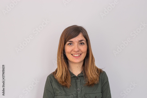 Photo of a young and attractive woman looking corporative with a shirt smiling at the camera, looking professional and ready to do bussiness with a white background