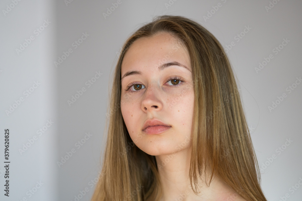 Close up portrait of a pretty teenage girl with long natural blonde hair and smooth skin looking at the camera. Studio shot Close up portrait of a pretty teenage girl with long natural blonde hair and smooth skin looking at the camera. Studio shot