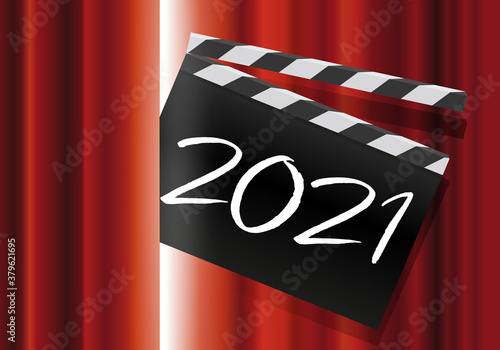 Un clap de cinéma avec l’inscription 2021, passe au travers du rideau rouge d’une scène de spectacle, pour présenter la nouvelle année.