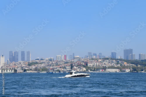 Speed-boat floats along the Bosphorus against the backdrop of the cityscape of Istanbul, Turkey