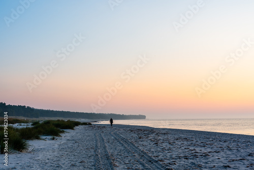 sunrise over the sea with a beach walker
