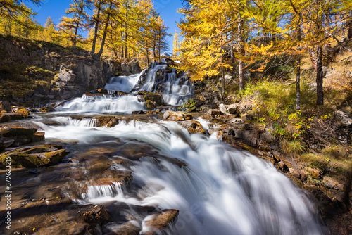 Fototapeta Naklejka Na Ścianę i Meble -  Fontcouverte Waterfall in Autumn with larch trees in the Claree Upper Valley. Nevache, Hautes-Alpes (05), Alps, France