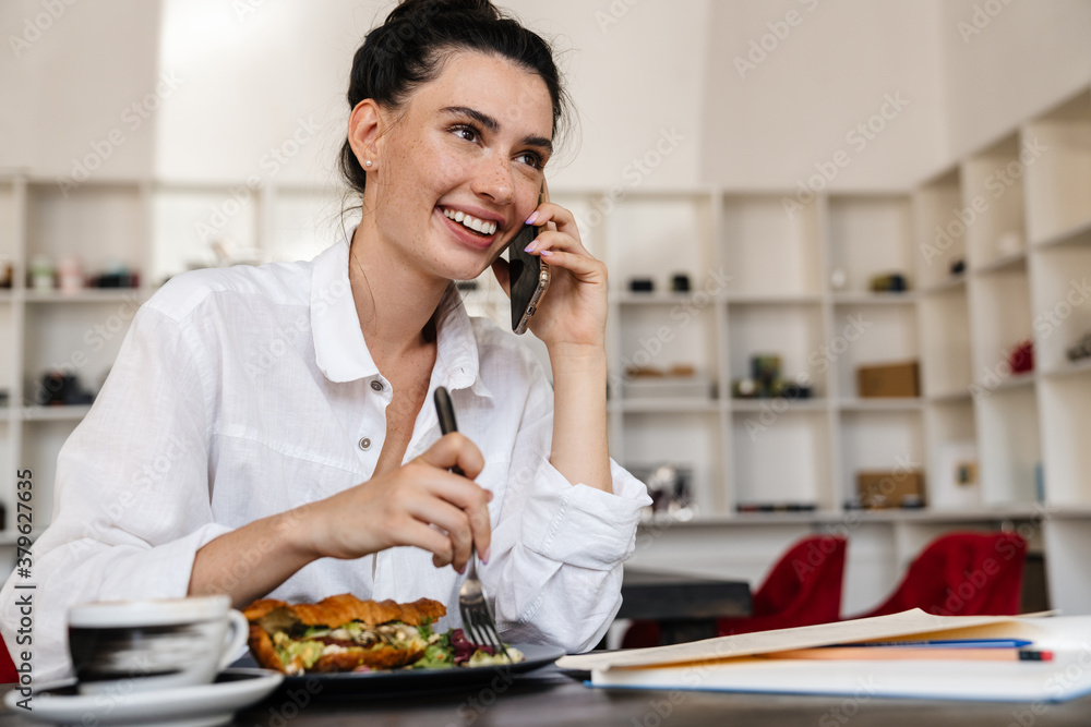 Smiling young woman having breakfast in a cafe Smiling young woman having breakfast in a cafe