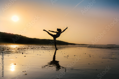 Child ballerina silhouette on the beach