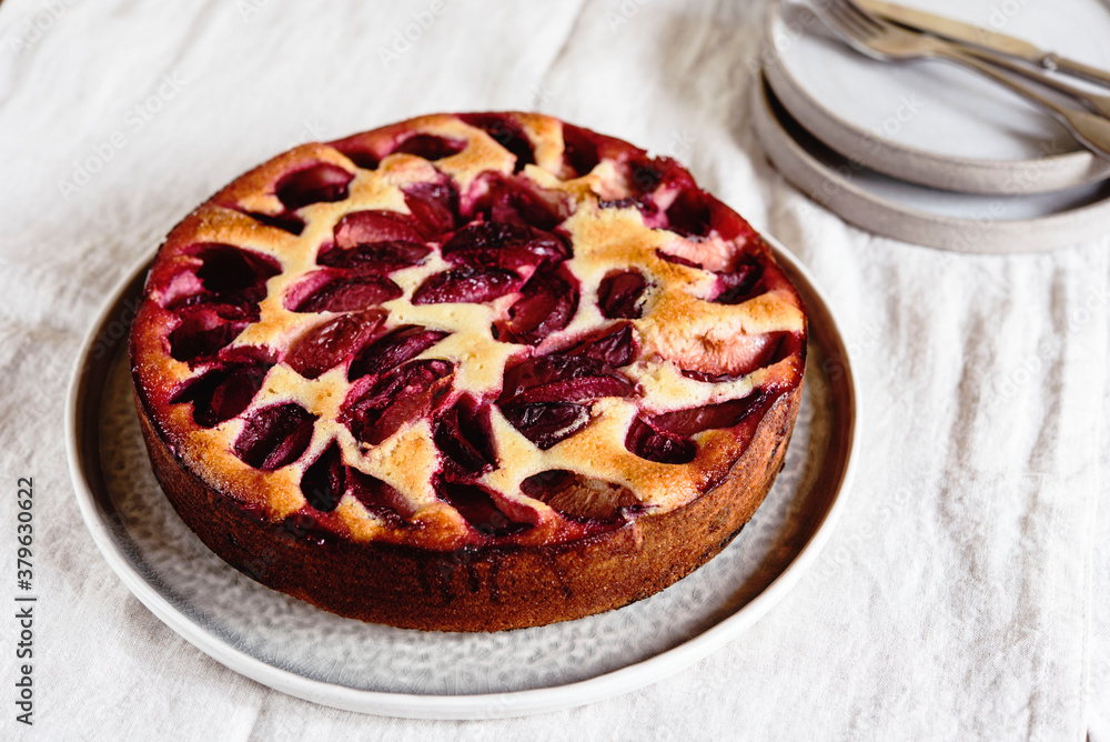 Homemade Ricotta Plum Cake on beige linen tablecloth. Cottage cheese casserole with vanilla, semolina and plums. Selective focus Homemade Ricotta Plum Cake on beige linen tablecloth. Cottage cheese casserole with vanilla, semolina and plums. Selective focus