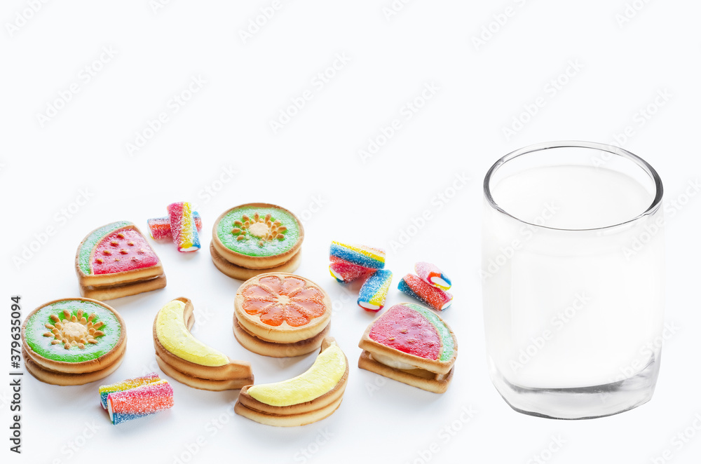 Cookies covered with multi-colored fruit jelly and a glass of milk on a white background. Selective focus Cookies covered with multi-colored fruit jelly and a glass of milk on a white background. Selective focus