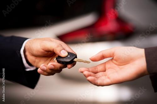 hand a car key to a buyer