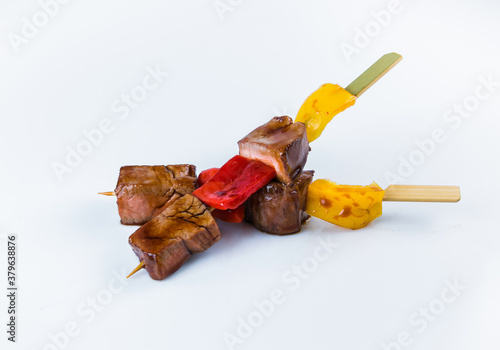 Japanese Beef Skewers with bell pepper served with sauce. Yakitori Beef isolated on white background. Pan Asian dish isolation. Meat Kusiyaki photo