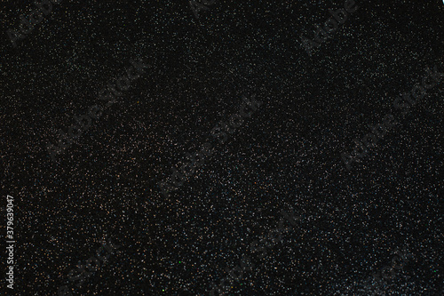 Christmas silver glitter on black background. Holiday abstract texture