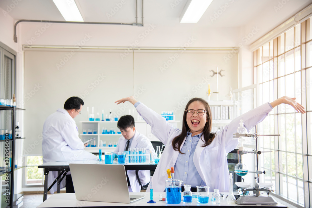 Obraz premium Team of chemists working in the lab Asian doctor holding Covid-19 or coronavirus Blood Sample on laboratory Background