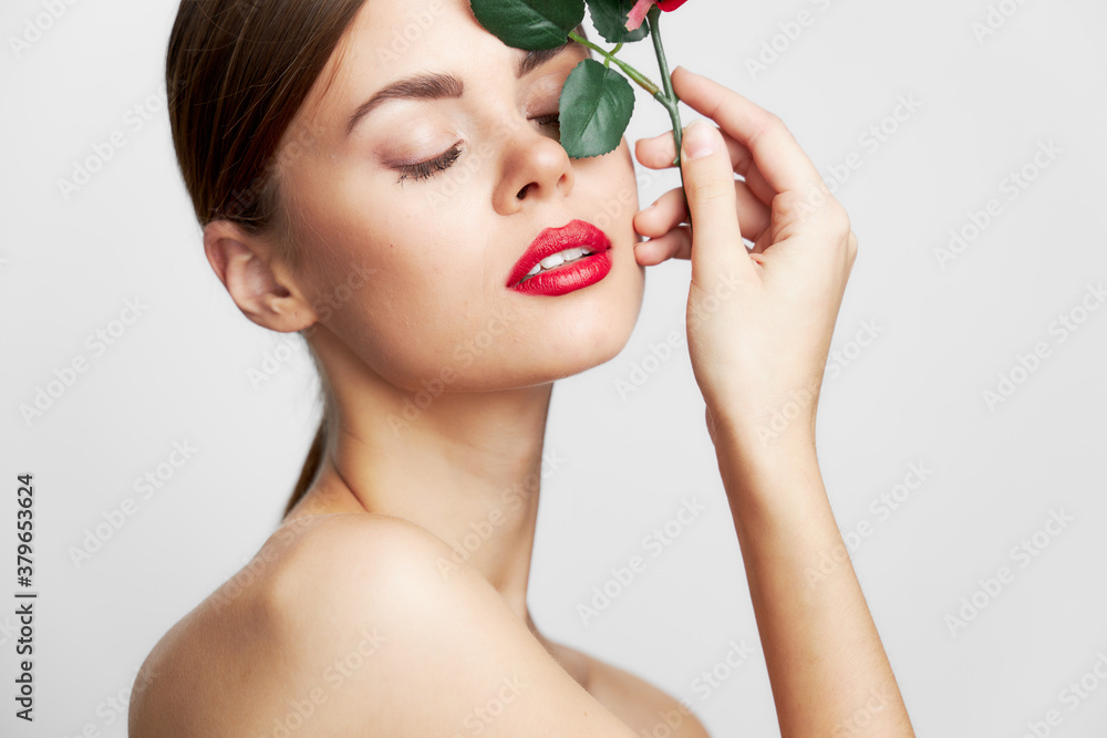 Sexy woman clear skin With his eyes closed he holds a rose near his face Sexy woman clear skin With his eyes closed he holds a rose near his face