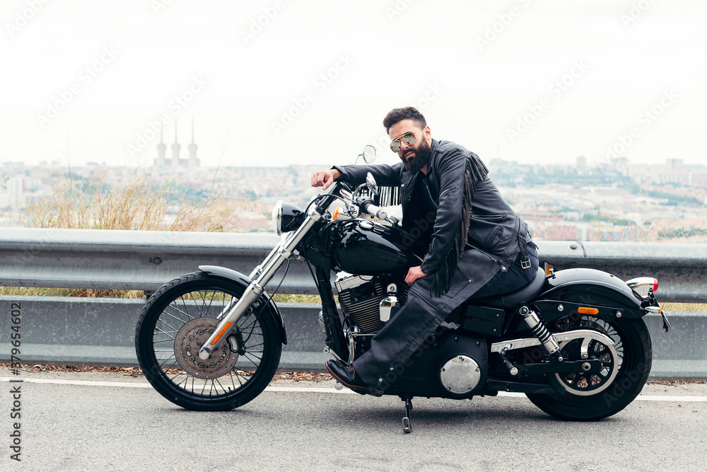 Obraz premium biker sitting on his motorcycle on the road