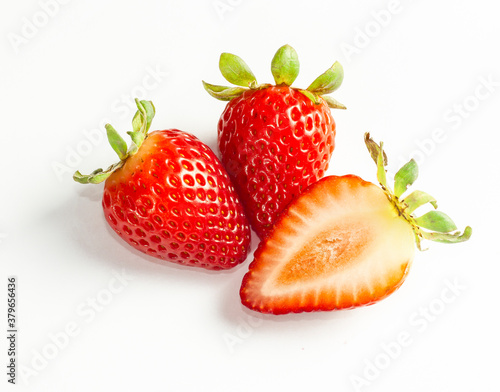 A close-up picture of a bright three and half red strawberry or berry as a fruit or food. An isolated white background is a naturally fresh fruit.