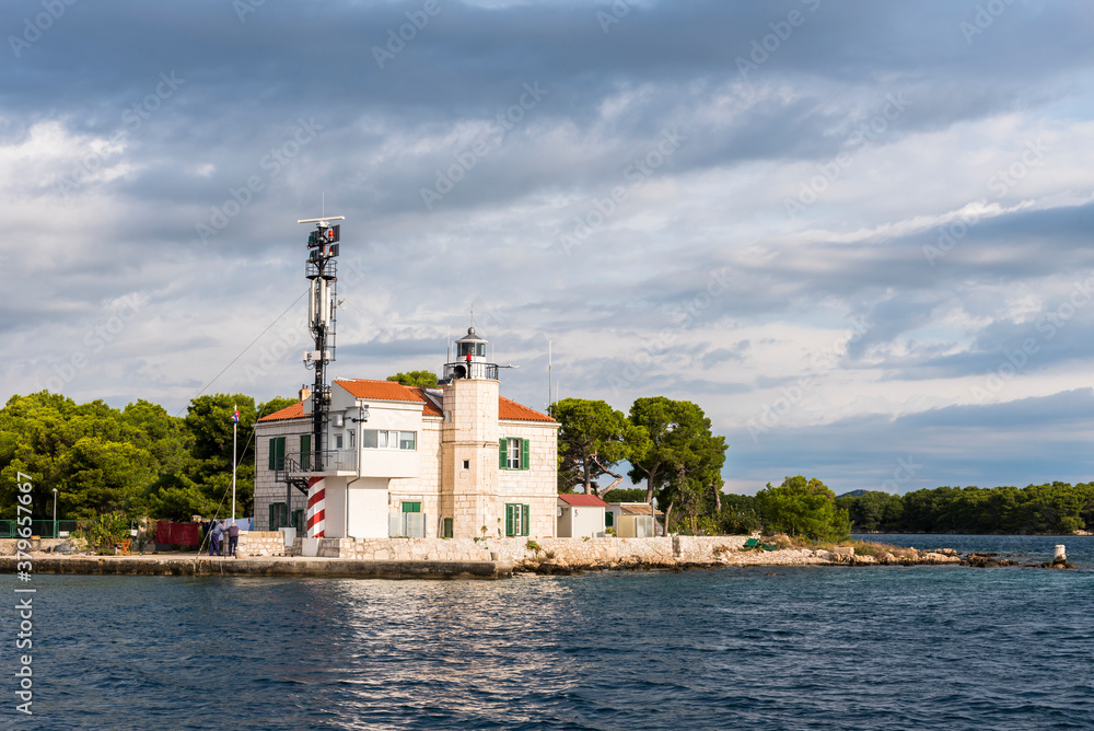 Lighthouse at the entrance to the bay near the town of Sibenik, Croatia, on the background of a stormy sky