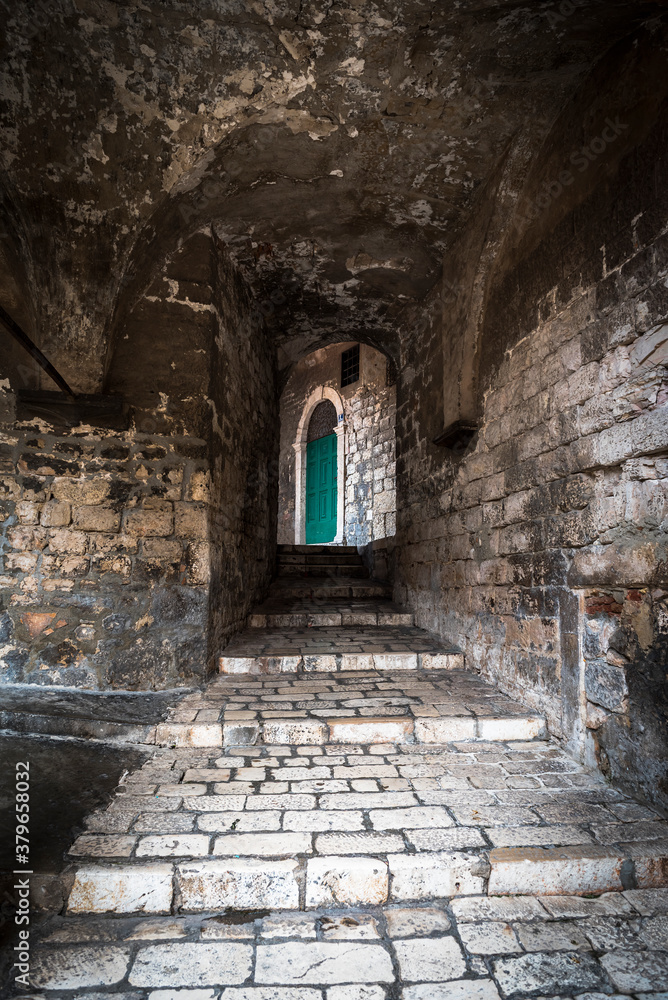 Medieval narrow street with a green door in Sibenik, Croatia