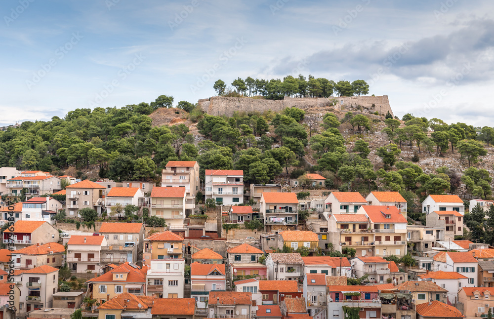 View of the fortress on the hill and houses with red roofs of Sibenik, Croatia