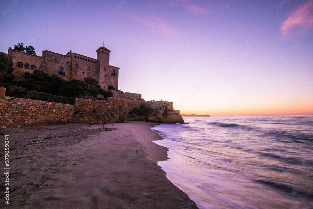Beautiful sunrise at Castell de Tamarit, near Tarragona, Costa Dorada, Catalonia in Spain. This is a Romanesque style castle, located on a promontory on the shores of the Mediterranean Sea.
