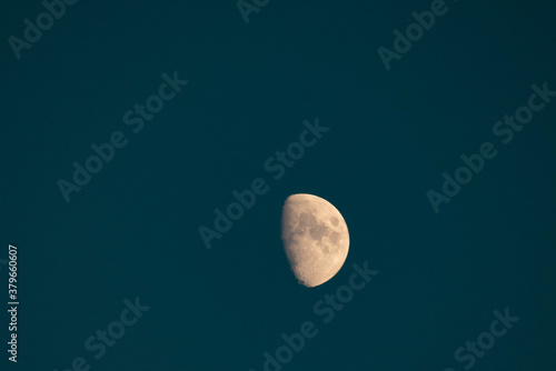 luna senza stelle in cielo blu piombo con crateri visibili photo