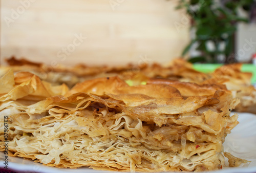 Balkan cuisine, traditional homemade burek or borek on table with wooden background, closeup, tasty pastry photo