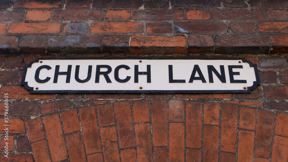 Old English road sign indicating Church Lane on plaque attached to brickwork Old English road sign indicating Church Lane on plaque attached to brickwork
