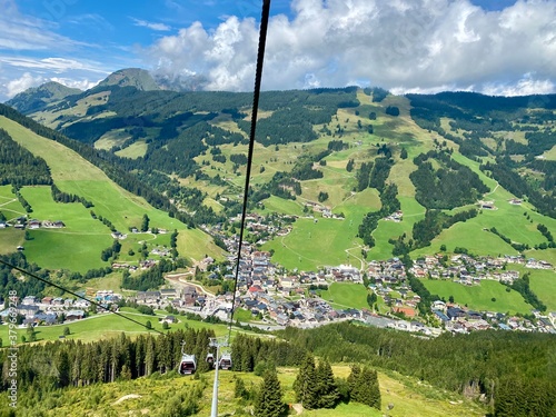 Aerial view on Saalbach village and mountains in Saalbach-Hinterglemm skiing region in Austria on a beautiful summer day from cableway on the village with holiday ressorts, the church and other photo