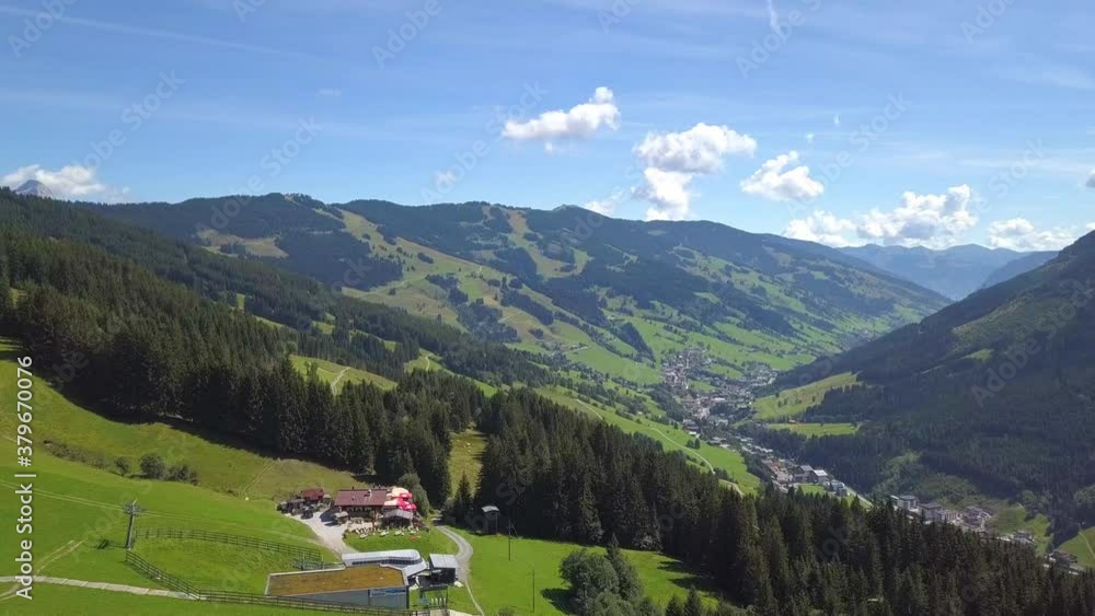 Aerial view on cozy hut with mountain panorama from Hinterglemm to Saalbach in the Alps in Austria. on a sunny summer day. Aerial view on cozy hut with mountain panorama from Hinterglemm to Saalbach in the Alps in Austria. on a sunny summer day.