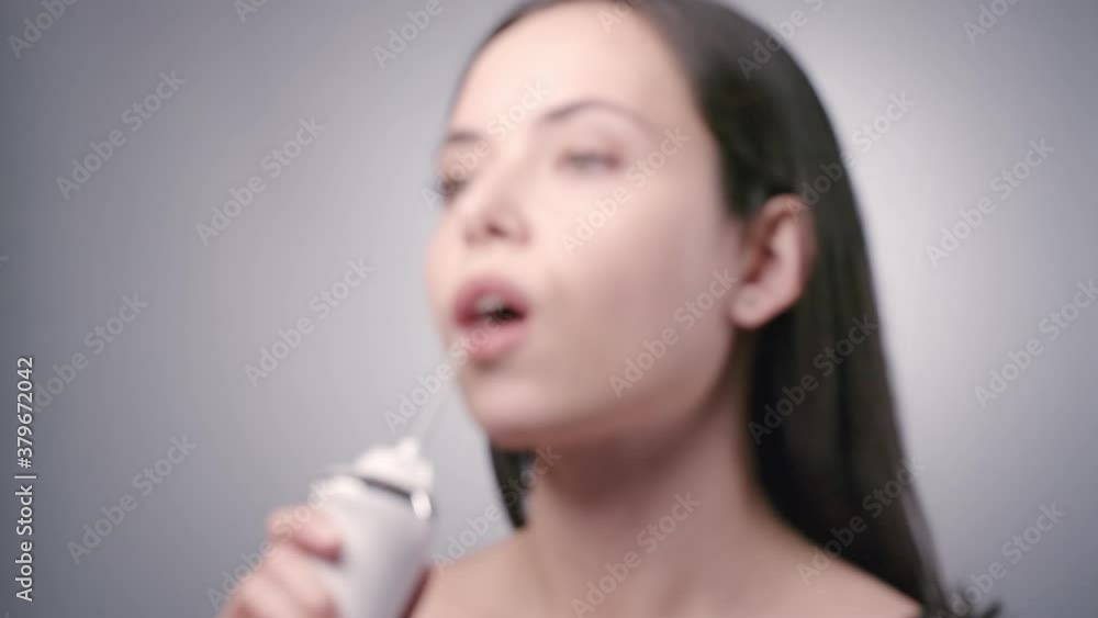 Young woman with long dark hair cleaning teeth with water flosser at morning in bathroom. Morning healthcare routine. Slow motion. 4k 100 fps Young woman with long dark hair cleaning teeth with water flosser at morning in bathroom. Morning healthcare routine. Slow motion. 4k 100 fps