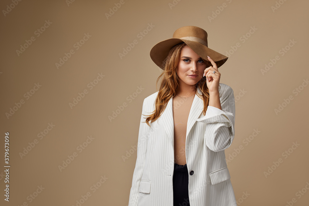 Beautiful young woman in white blazer and brown hat. Plus size model Beautiful young woman in white blazer and brown hat. Plus size model