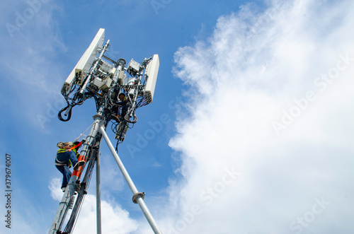 Obraz na płótnie technician working on high telecommunication tower,worker wear Personal Protection Equipment for working high risk work,inspect and maintenance equipment on high tower