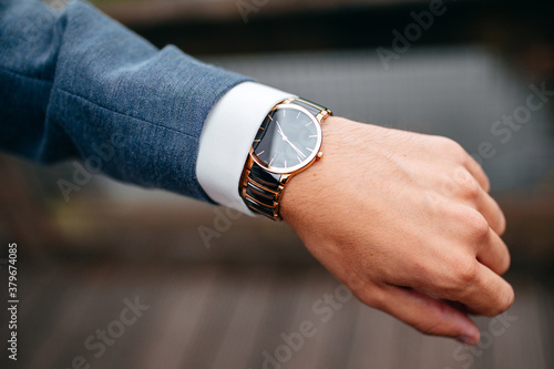Mann schaut auf eine Armbanduhr