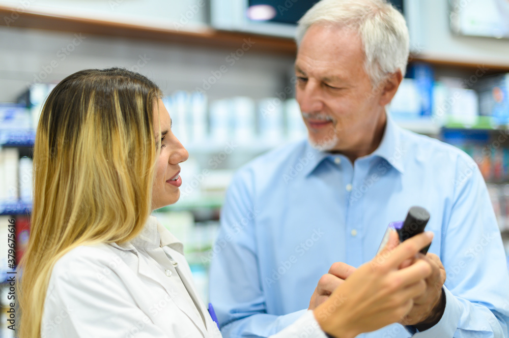 Obraz premium Young female pharmacist dealing with a customer