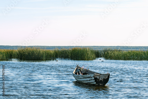 Lonely wooden rowing fishing boat on Lake Drivyaty at sunset. Braslav lakes. Belarus