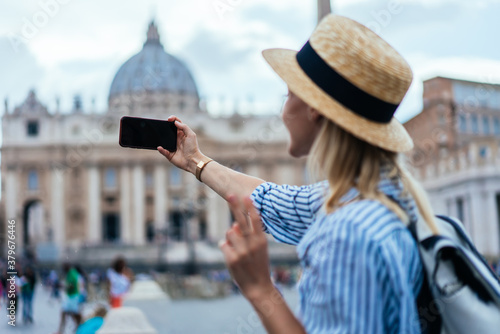 Canvas Print Hipster female tourist taking selfie in front of cathedral in Rome