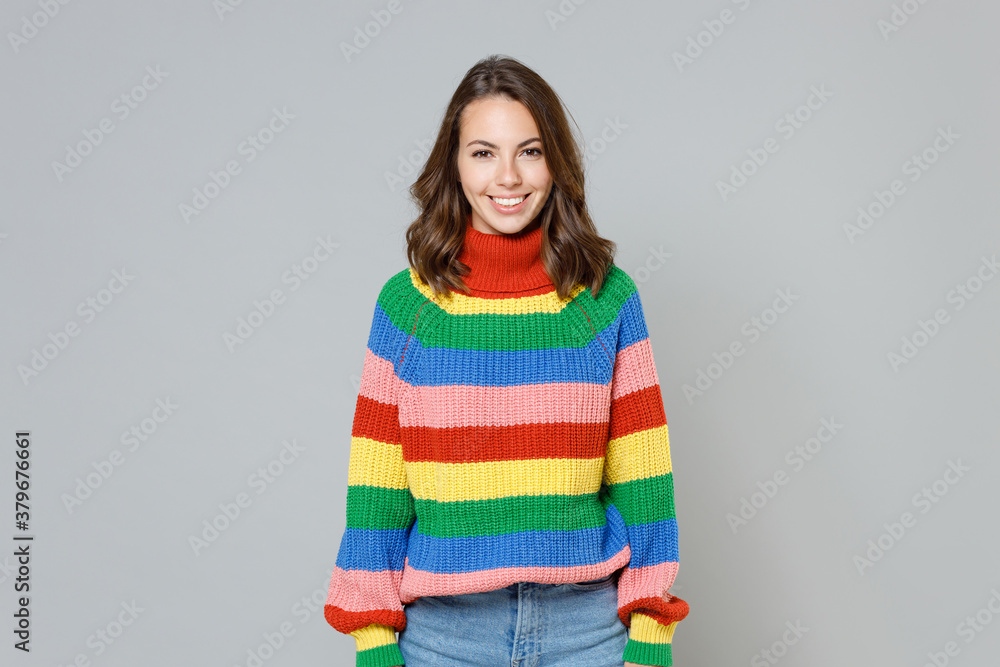 Smiling cheerful charming pretty beautiful attractive young brunette woman 20s wearing casual colorful knitted sweater standing looking camera isolated on grey colour background, studio portrait. Smiling cheerful charming pretty beautiful attractive young brunette woman 20s wearing casual colorful knitted sweater standing looking camera isolated on grey colour background, studio portrait.