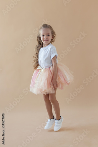 little child girl dreams of becoming ballerina in a pink tutu skirt.