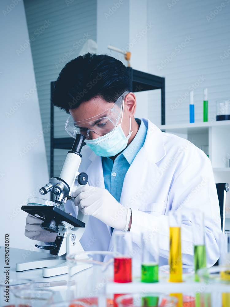 Asian male scientist Is working seriously Chemistry experiment With looking at the microscope In the laboratory, the color tone image. Asian male scientist Is working seriously Chemistry experiment With looking at the microscope In the laboratory, the color tone image.