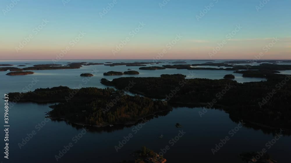 Aerial view over silhouette islands, on a serene, summer evening, in the Finnish archipelago, Raasepori, Finland - tracking drone shot Aerial view over silhouette islands, on a serene, summer evening, in the Finnish archipelago, Raasepori, Finland - tracking drone shot