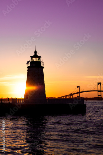 Sunset over Newport Harbor Lighthouse with bridge and colorful sky