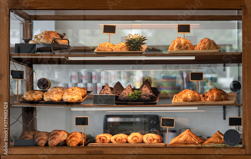 Bilde på lerret Variety baked bread and dessert in glass showcase at bakery
