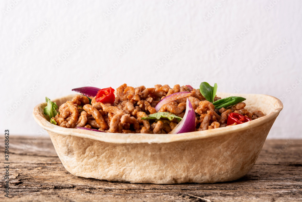 Mexican barquita taco with beef, chilli, tomato, onion and spices on wooden table Mexican barquita taco with beef, chilli, tomato, onion and spices on wooden table