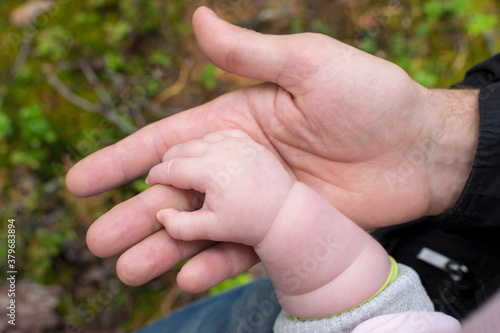 Elderly woman holding baby`s hand outdoors. © Tatiana