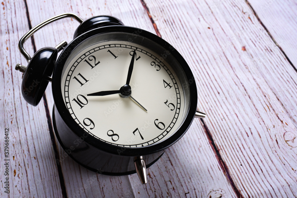 close-up black alarm clock on a white wooden background. Lost time concept. Business idea. Lifestyle close-up black alarm clock on a white wooden background. Lost time concept. Business idea. Lifestyle