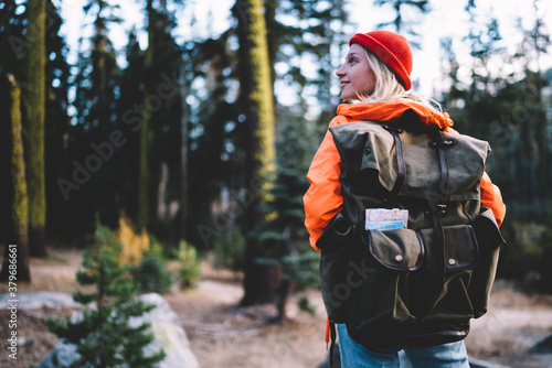 Cheerful woman with backpack in forest