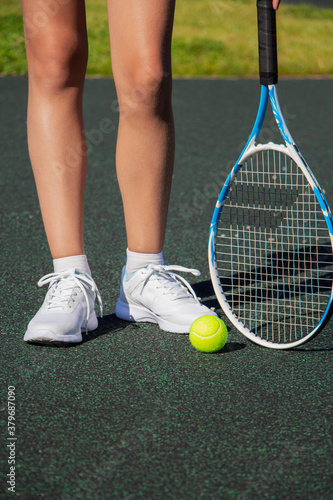 A tennis player with a racket stands on the tennis court. Sport