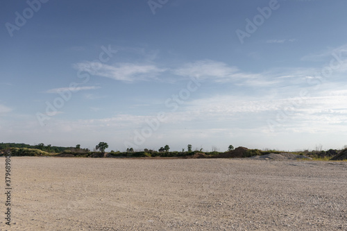 Large gravel background site with cloudy sky