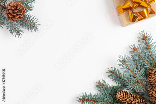 Christmas composition with fir tree branches, christmas tree cones and gift on white.