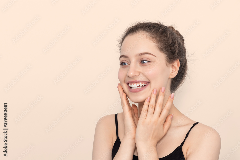 The girl smiles, touches her face with her hands. The girl smiles, touches her face with her hands.