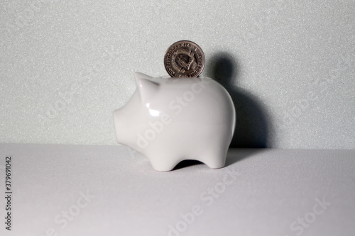 Coin from Yugoslavia falls into a white piggy bank