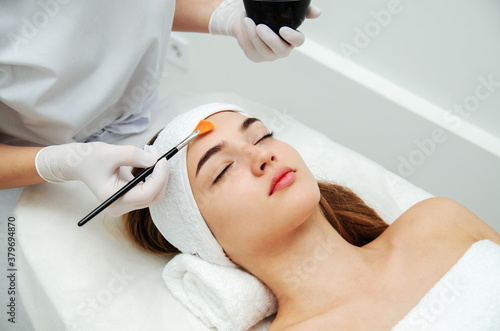 Woman getting face beauty treatment procedure in medical spa center