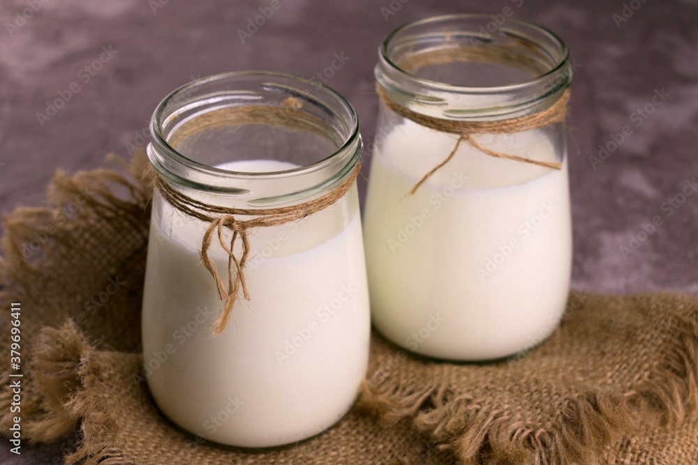 Two jars with fresh milk on a gray background.
Close-up.
Two jars with fresh milk on a gray background.
Close-up.